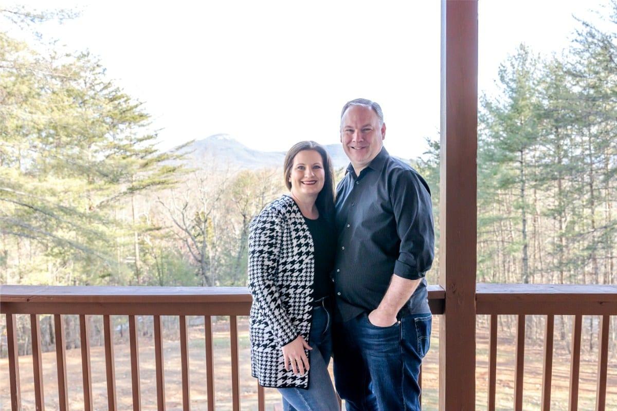 Todd and Jenny Chandler on the back deck of their home in Helen, Georgia, with Mount Yonah behind them